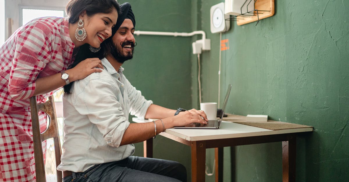 Need Schengen visa with UK work permit and indian passport [closed] - Happy young cuddling Indian couple using laptop during work at home