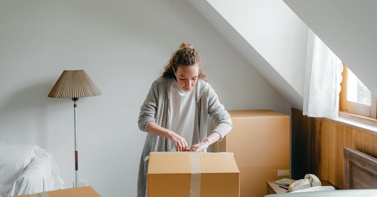 New Schengen visa or extension of old Schengen visa? - Slim female in cardigan unpacking cardboard box put on bed close to suitcase while standing near window in attic style room in daylight New Schengen visa or extension of old Schengen visa? - Slim female in cardigan unpacking cardboard box put on bed close to suitcase while standing near window in attic style room in daylight