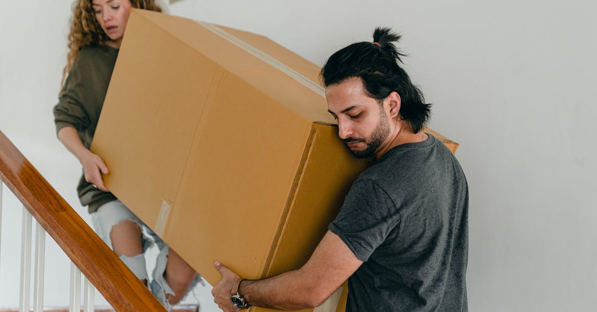 Newly married last name change for wife? [closed] - Focused couple in casual clothes carrying big carton box together down stairs in new house while moving personal items