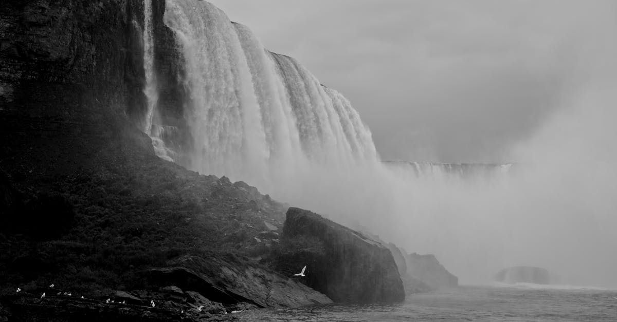 Night travel Niagara Falls to NYC - Grayscale Photo of Waterfalls on Rocky Mountain Night travel Niagara Falls to NYC - Grayscale Photo of Waterfalls on Rocky Mountain