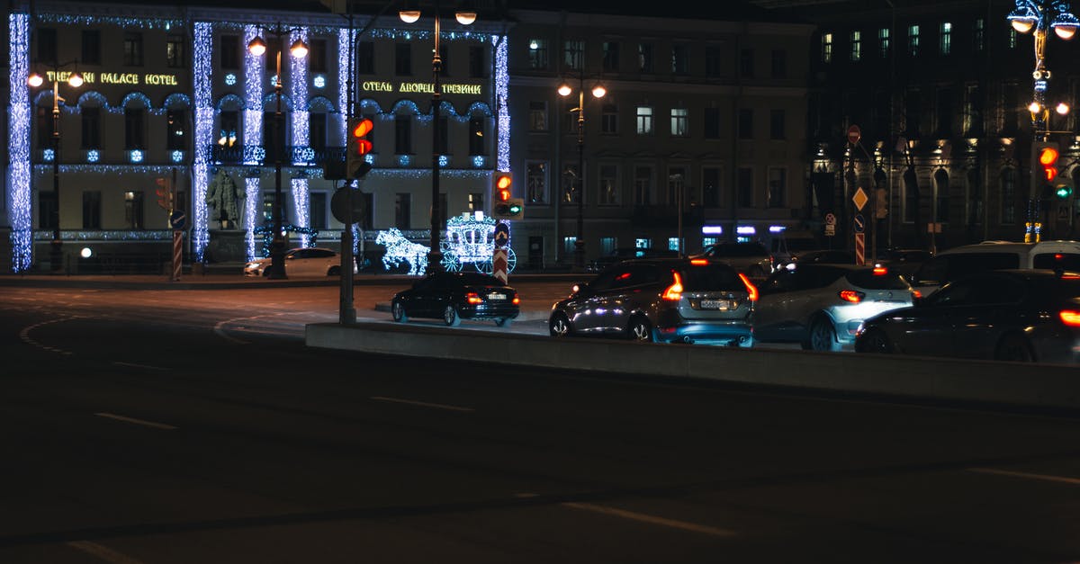 Nightlife in Russia - Modern cars driving on road near age illuminated buildings in evening