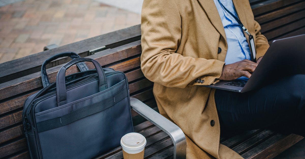 NOC from employer for Schengen visa - Crop faceless black man using laptop on street bench NOC from employer for Schengen visa - Crop faceless black man using laptop on street bench