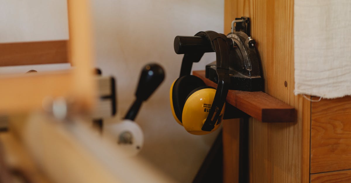 Noise cancelling headphones you can turn the noise cancellation on/off in [closed] - Yellow noise cancelling headphones for carpentry work hanging on timber shelf in workshop