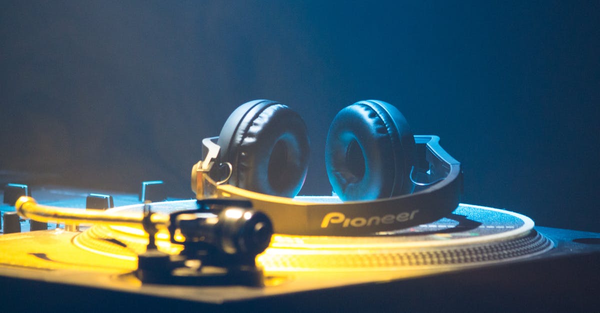 Noise cancelling headphones you can turn the noise cancellation on/off in [closed] - Contemporary headset on platter disc of music controller with knobs and faders in yellow neon light on blue background