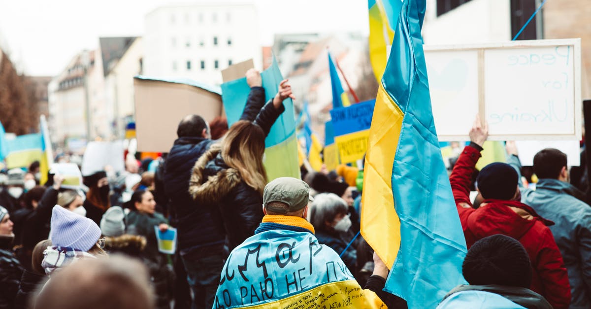 Non EU travelling with minor EU children to UK - People in Blue and Yellow Jacket Raising Hands Non EU travelling with minor EU children to UK - People in Blue and Yellow Jacket Raising Hands