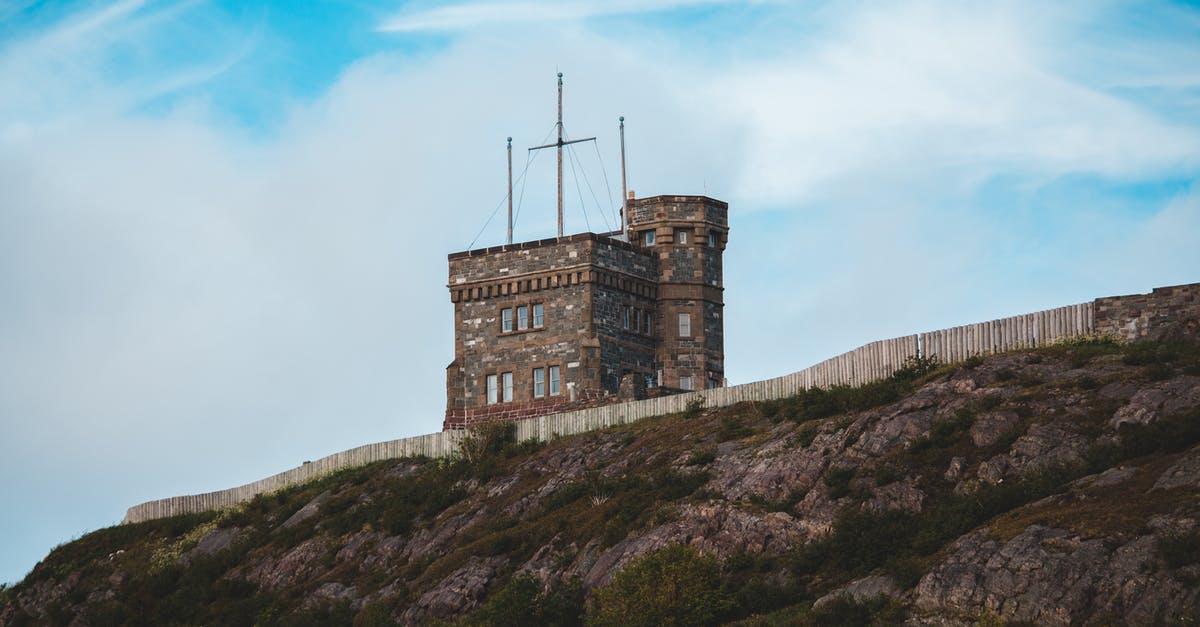 Non-commercial long 7 day retreats in Japan? - Aged stone house behind old long fence on rocky green cliff on sunny clear day Non-commercial long 7 day retreats in Japan? - Aged stone house behind old long fence on rocky green cliff on sunny clear day