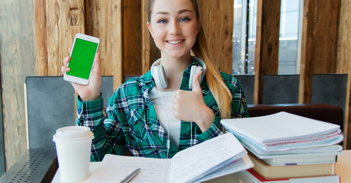 Non-EU citizen, student in Spain holding a residence permit. Do I need a UK visa? - Smiling Woman Holding White Android Smartphone While Sitting Front of Table