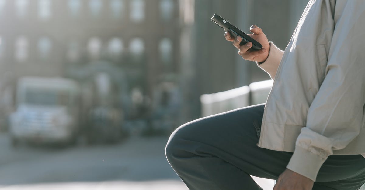 NON-EU spouse of EU citizen at the same time a british citizen [closed] - Side view of crop unrecognizable male with raised leg surfing internet on cellphone on roadway in sunny city