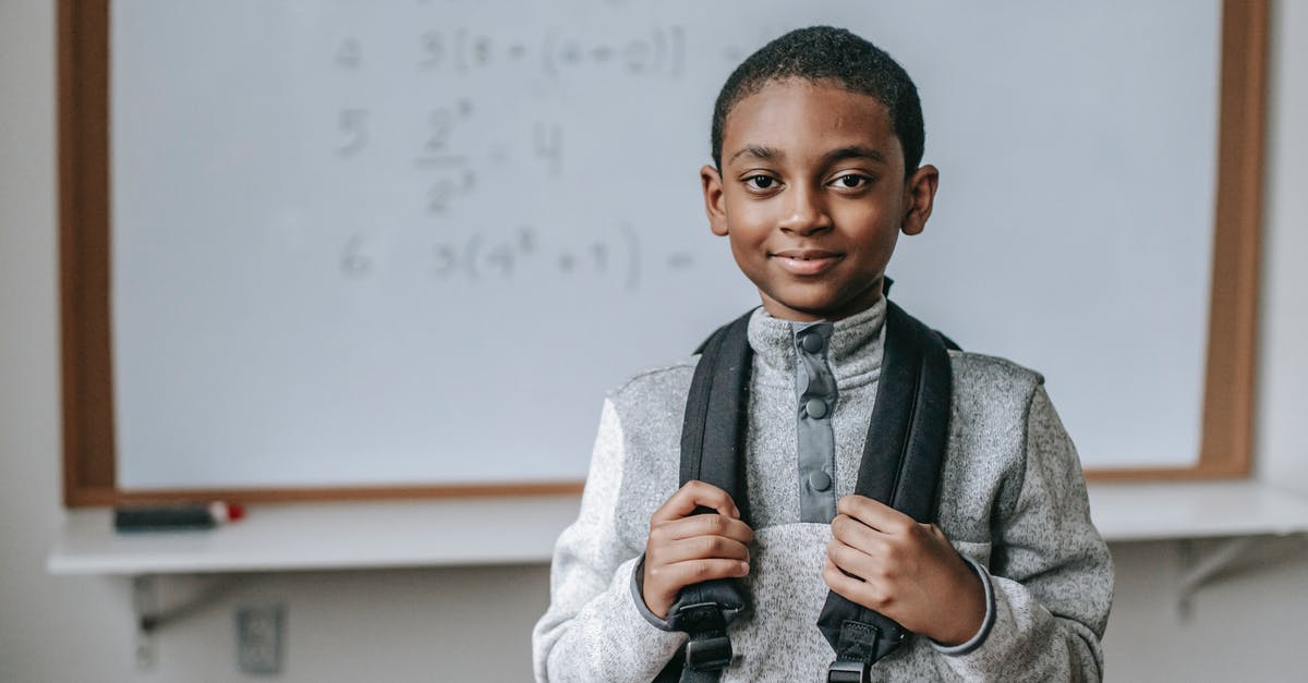 Number of check-in Bags on Indigo Airlines? - Smiling black schoolboy near white board in classroom Number of check-in Bags on Indigo Airlines? - Smiling black schoolboy near white board in classroom