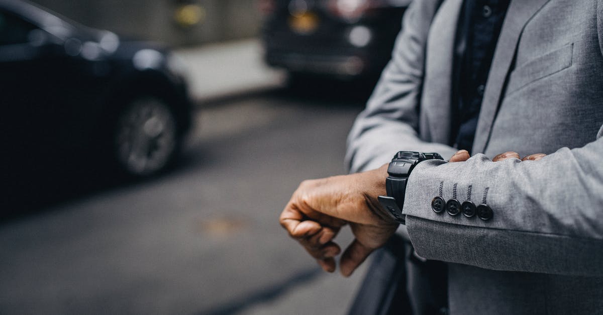 Obese guy first time flying [duplicate] - Crop unrecognizable punctual black businessman in formal outfit checking time on sidewalk in modern city