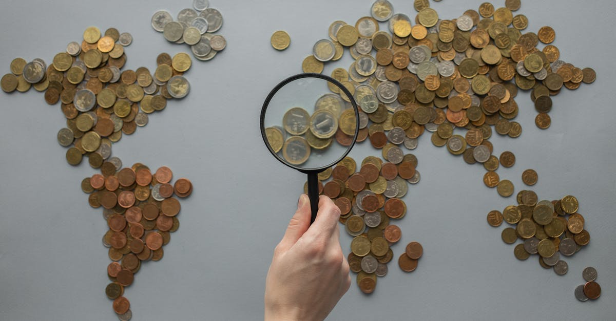 obtain UK visa from Egypt and travel from another country - Anonymous person with magnifying glass over world map of coins
