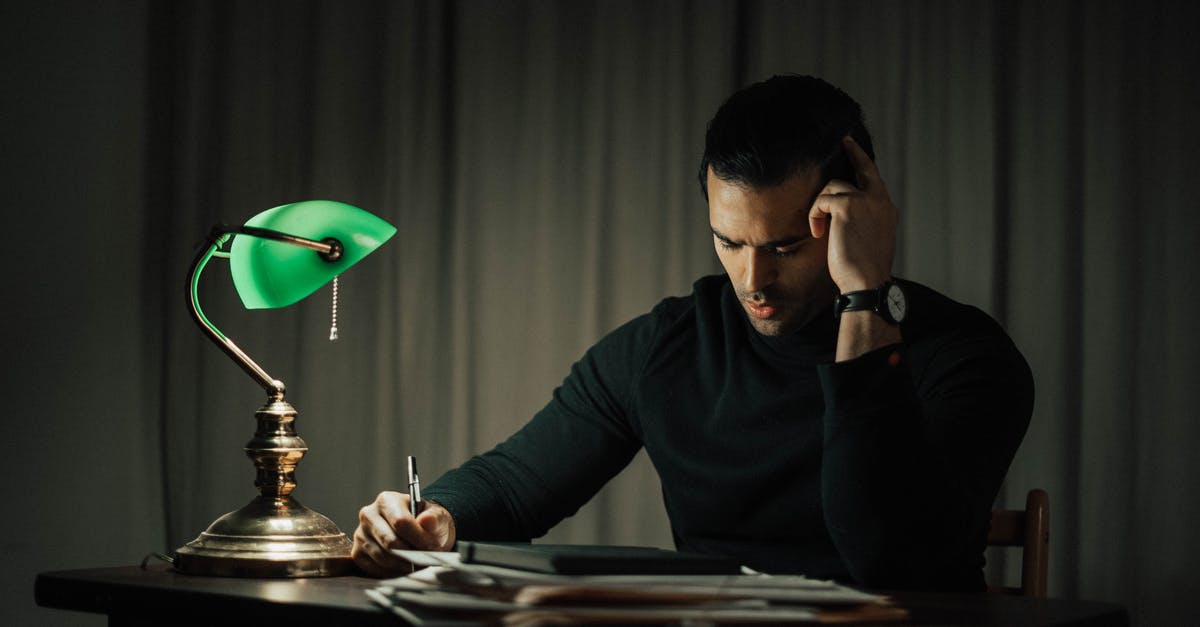 Occupancy rate and late reservations - Thoughtful man writing on paper at table Occupancy rate and late reservations - Thoughtful man writing on paper at table