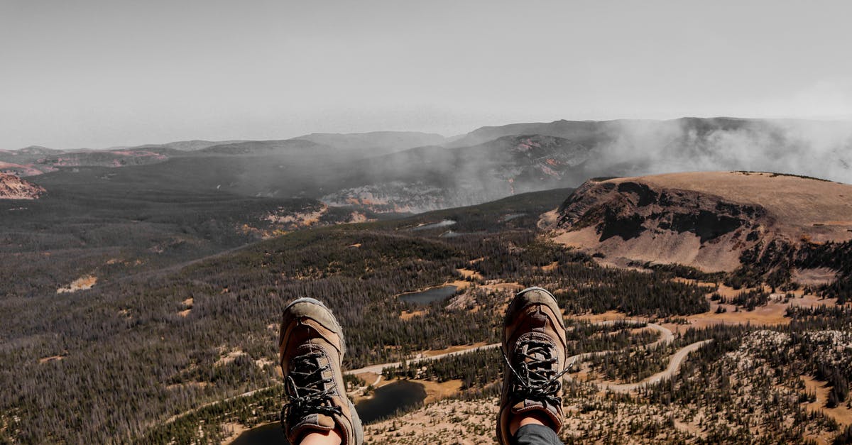 One person not traveling first leg of the journey - Crop hiker relaxing on mountain after achieving peak One person not traveling first leg of the journey - Crop hiker relaxing on mountain after achieving peak