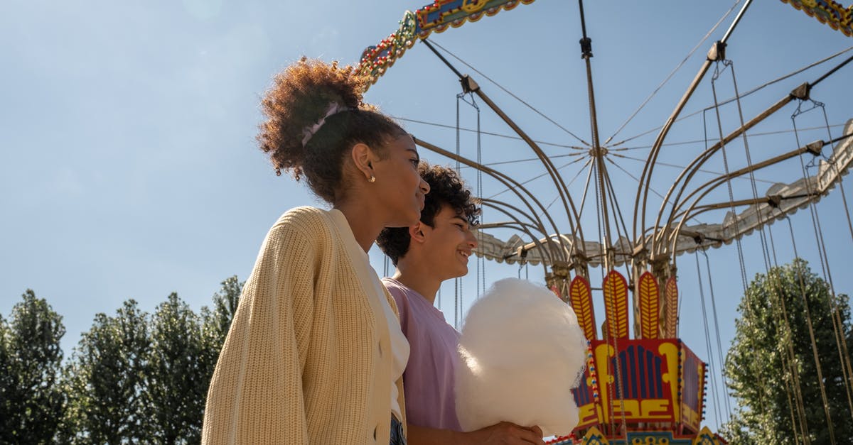 Opening hours in Maastricht, the Netherlands, for first day of year - Teenage couple walking by big carousel and boy holding cotton candy Opening hours in Maastricht, the Netherlands, for first day of year - Teenage couple walking by big carousel and boy holding cotton candy
