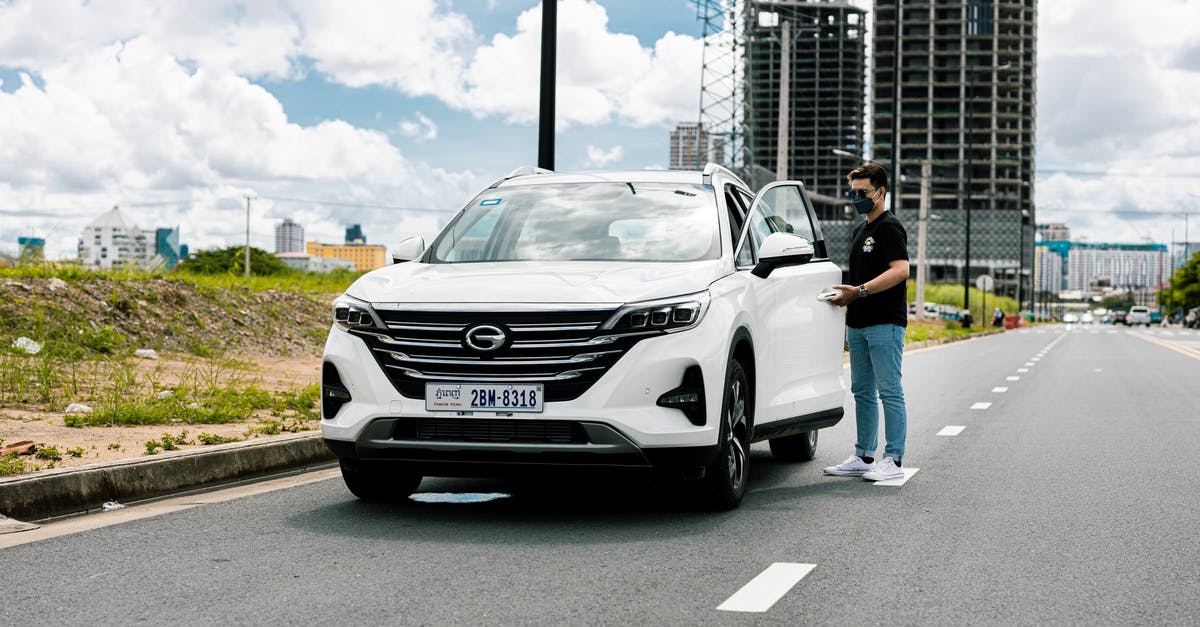 Out-of-country plates on bill-by-plate toll road - Couple Standing Beside White Mercedes Benz Car on Road Out-of-country plates on bill-by-plate toll road - Couple Standing Beside White Mercedes Benz Car on Road