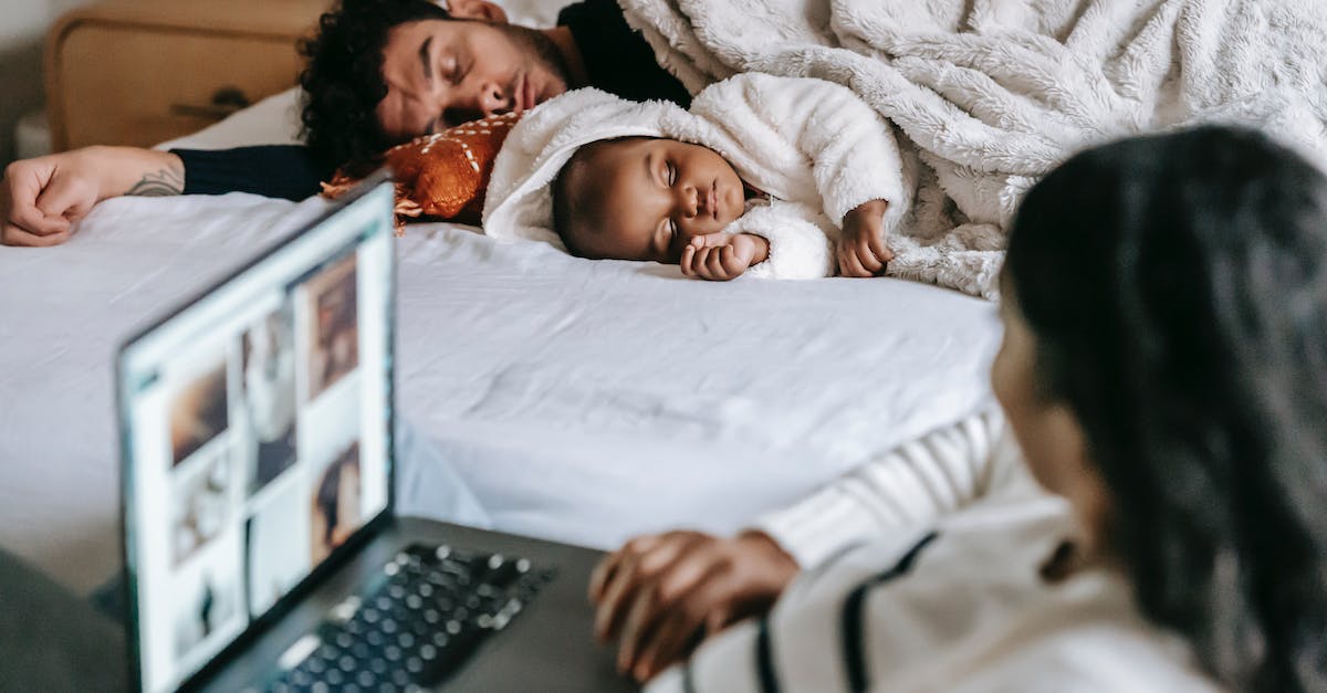Overnight connection in Guangzhou - where do I sleep? - Anonymous ethnic mother working on netbook near baby and husband sleeping in bedroom Overnight connection in Guangzhou - where do I sleep? - Anonymous ethnic mother working on netbook near baby and husband sleeping in bedroom