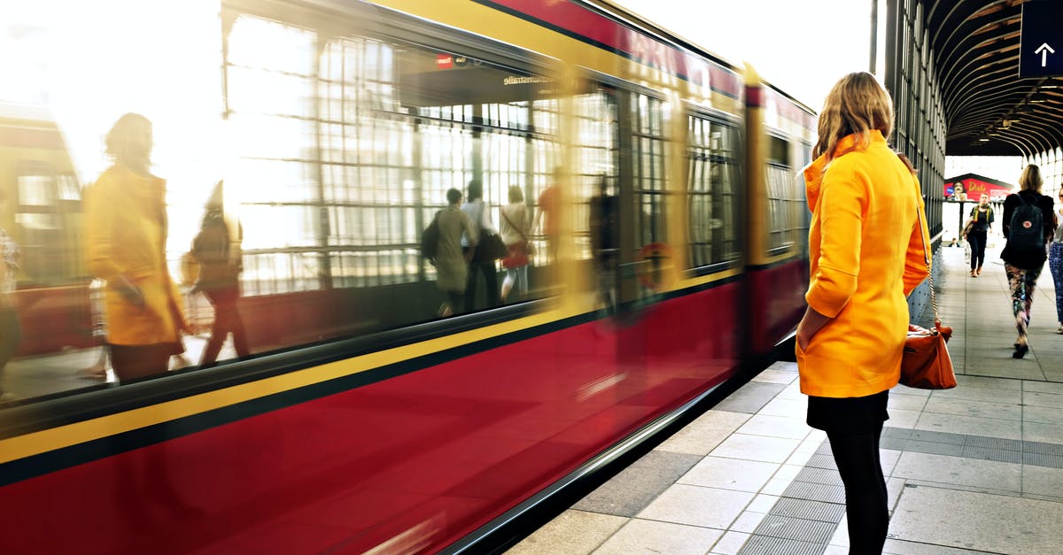 Overnight train: London to Berlin - Woman Standing Beside Red Train Overnight train: London to Berlin - Woman Standing Beside Red Train