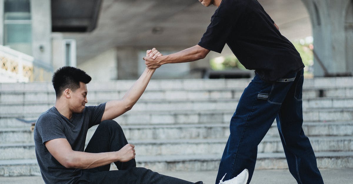Overstay schengen visa on ground of emergency? - Asian man helping friend to get up from ground Overstay schengen visa on ground of emergency? - Asian man helping friend to get up from ground