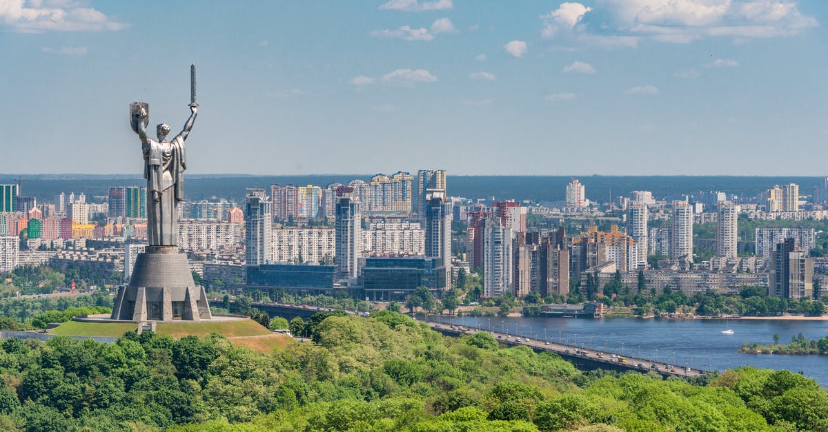 Overstayed in Ukraine - Motherland Monument among green trees on embankment in Kiev Overstayed in Ukraine - Motherland Monument among green trees on embankment in Kiev