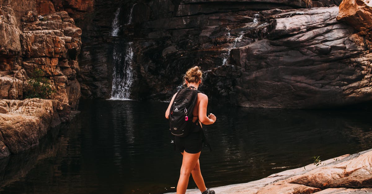 Overstaying a tourist visa in Chile, any other penalties despite a small fine? - Faceless female traveler near waterfall with hill and river