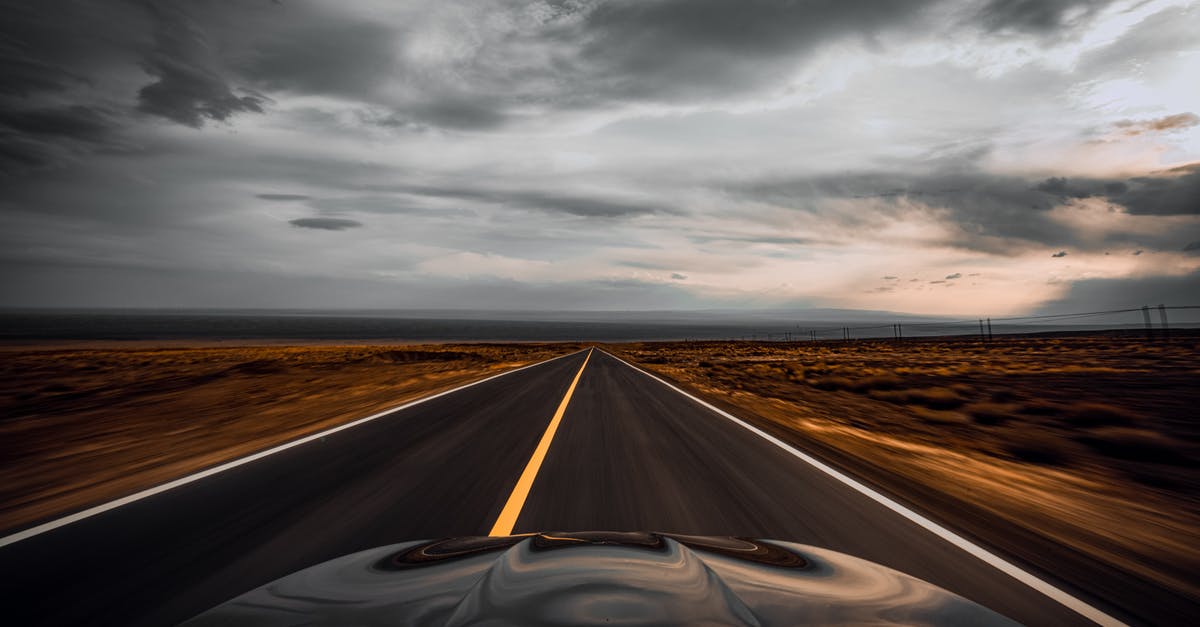 Owning a car in Japan and changing visa/departing for a long trip - Auto driving through dry desert valley on long straight roadway in overcast weather Owning a car in Japan and changing visa/departing for a long trip - Auto driving through dry desert valley on long straight roadway in overcast weather