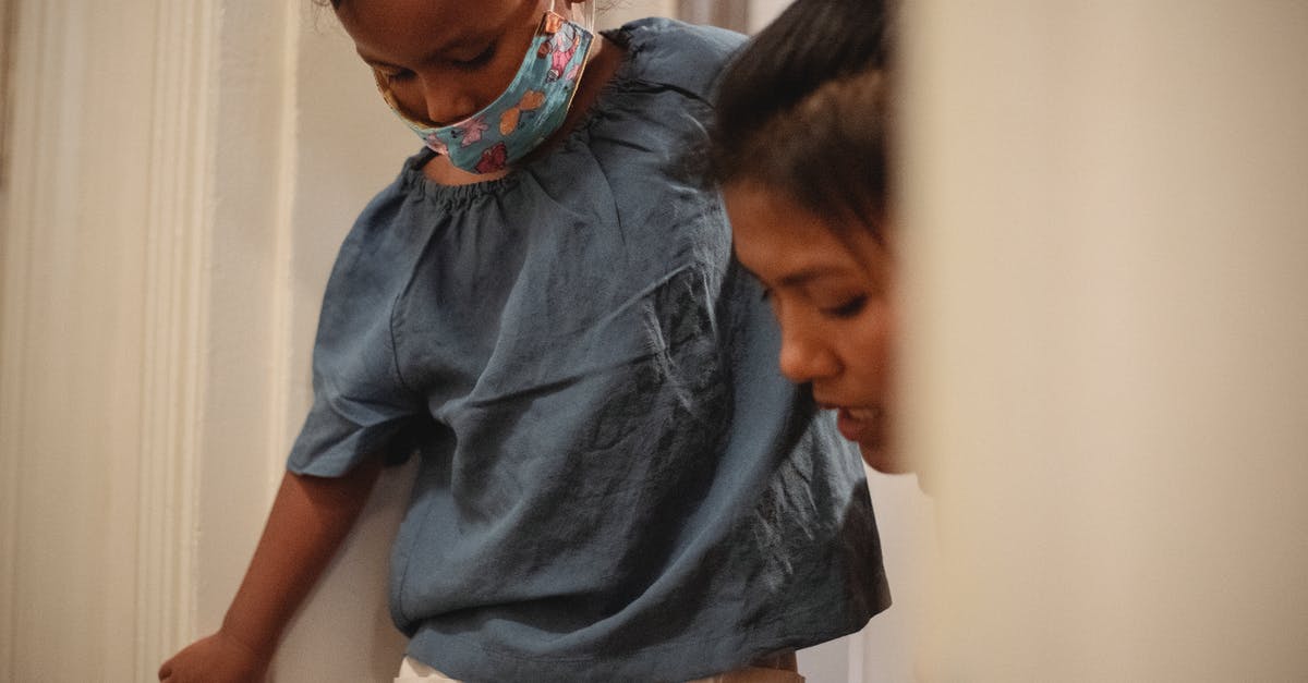 Parents going though medical issues and possibility of expediting I-130 - Caring Asian mother helping crop little girl with protective mask while standing in doorway in apartment before going on street Parents going though medical issues and possibility of expediting I-130 - Caring Asian mother helping crop little girl with protective mask while standing in doorway in apartment before going on street