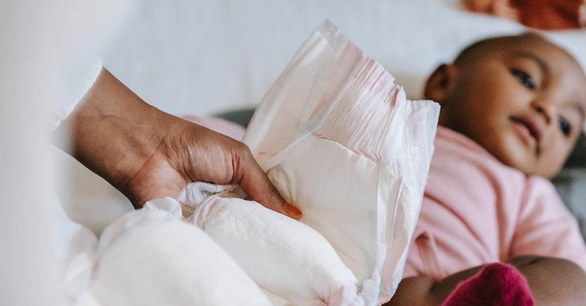 Parents name change UK standard visitor visa - Black mother changing diaper for baby Parents name change UK standard visitor visa - Black mother changing diaper for baby