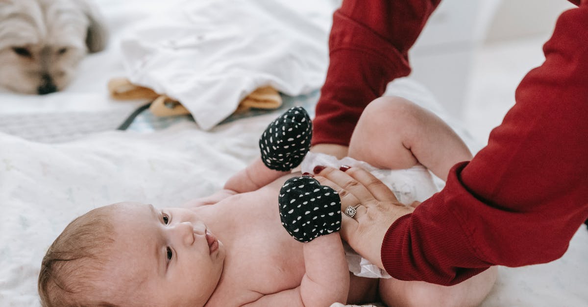 Parents name change UK standard visitor visa - Faceless mother changing diaper for newborn baby Parents name change UK standard visitor visa - Faceless mother changing diaper for newborn baby