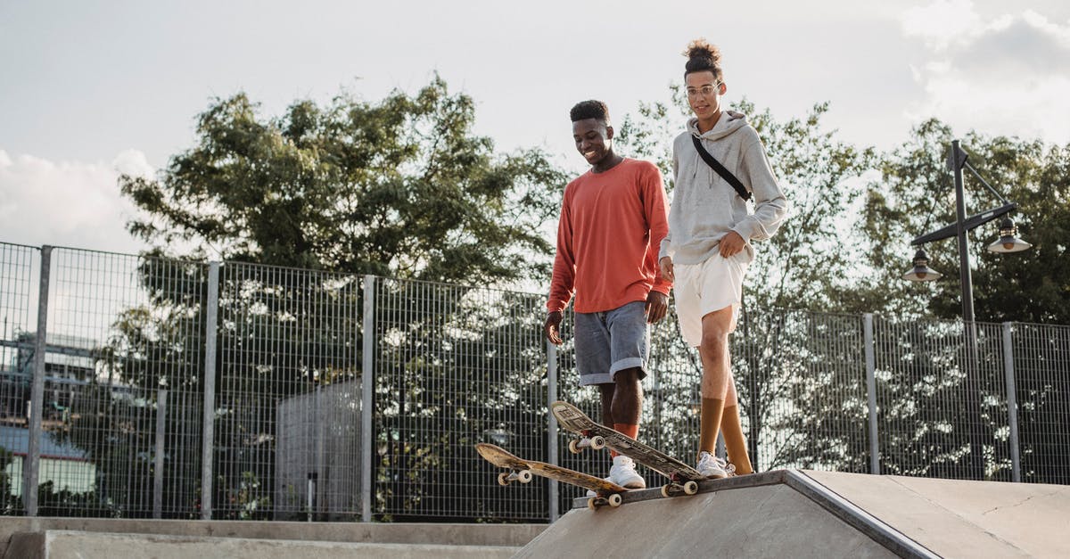 Park & Ride in Düsseldorf, coming from Belgium/Netherlands - From below of happy multiethnic friends standing on tail of boards before performing extreme stunt on ramp in skate park on summer day Park & Ride in Düsseldorf, coming from Belgium/Netherlands - From below of happy multiethnic friends standing on tail of boards before performing extreme stunt on ramp in skate park on summer day