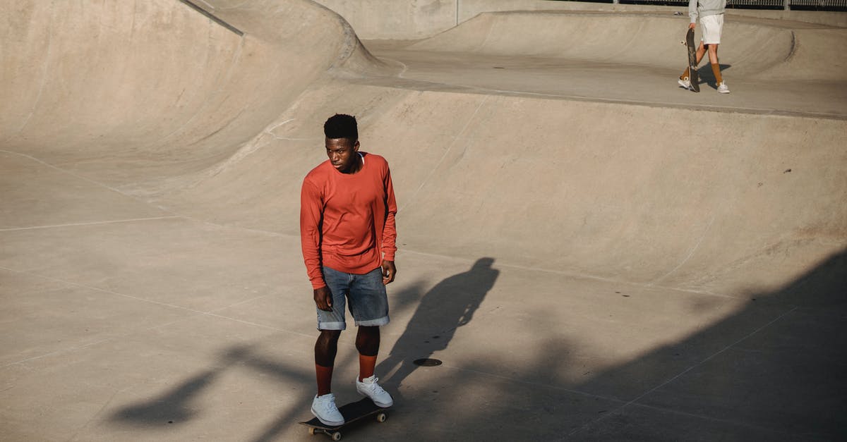 Park & Ride in Düsseldorf, coming from Belgium/Netherlands - Active young male skateboarder riding skateboard on asphalt ramp Park & Ride in Düsseldorf, coming from Belgium/Netherlands - Active young male skateboarder riding skateboard on asphalt ramp