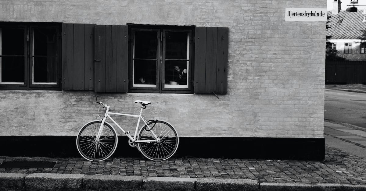 Parking in Copenhagen - White Bicycle Parked on a Roadside Made of Bricks Parking in Copenhagen - White Bicycle Parked on a Roadside Made of Bricks