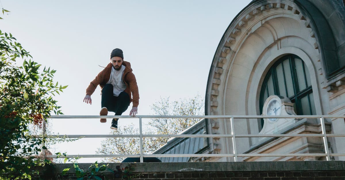 Parkour - Tricking - Free-running in Tokyo? - Young man jumping over railing on building roof Parkour - Tricking - Free-running in Tokyo? - Young man jumping over railing on building roof