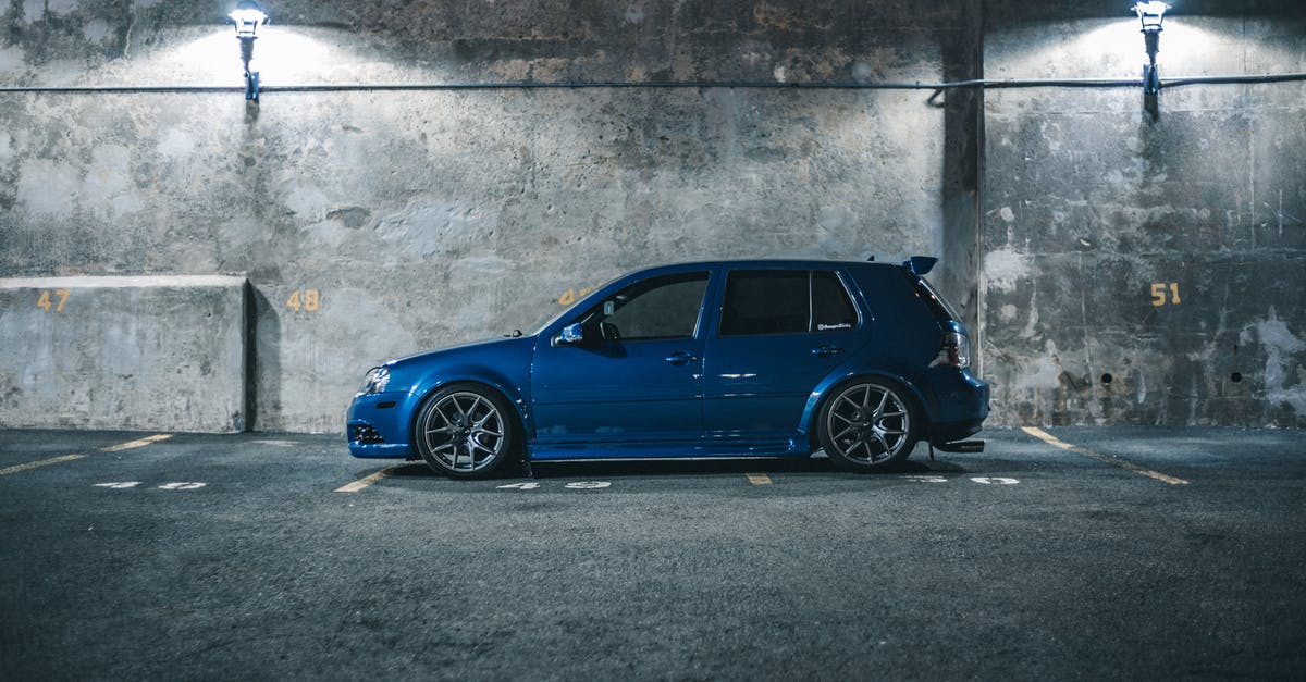 Passengers with baby asked to move across the aisle - Side view of blue hatchback automobile placed on parking place with marking lines near cement barrier in city street in night time Passengers with baby asked to move across the aisle - Side view of blue hatchback automobile placed on parking place with marking lines near cement barrier in city street in night time