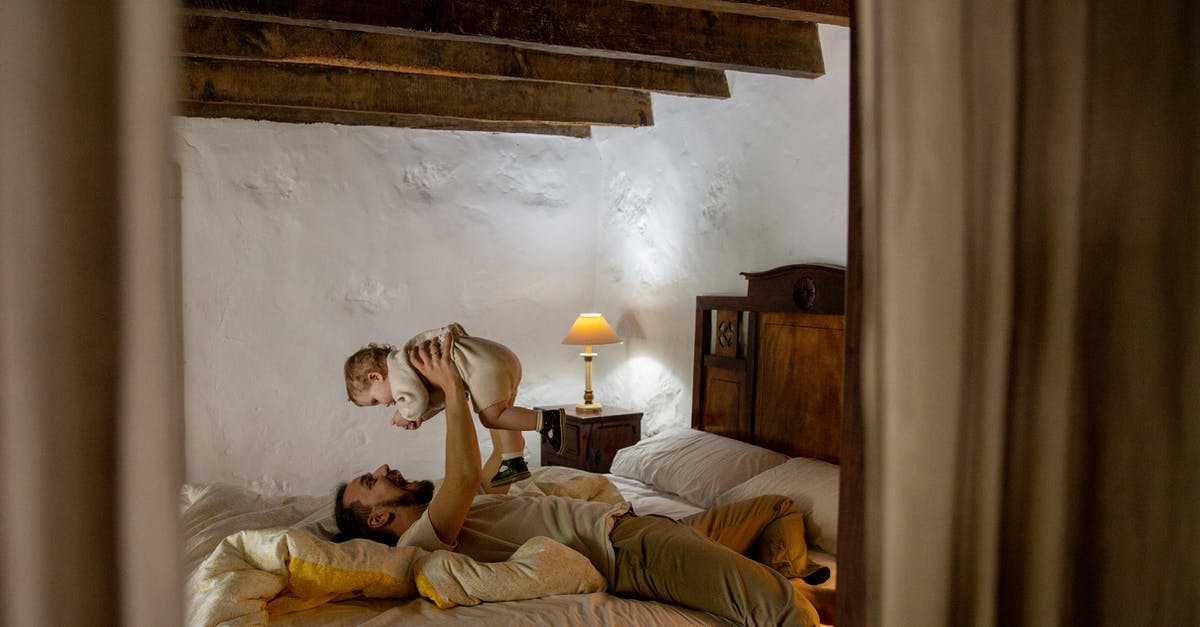 Passport Expiry for my kids less than a month and travelling Home country - Young father wearing casual clothes lying on back on bed and carrying adorable little child on rising hands in bedroom with rough white walls and ceiling beams while spending time at home together Passport Expiry for my kids less than a month and travelling Home country - Young father wearing casual clothes lying on back on bed and carrying adorable little child on rising hands in bedroom with rough white walls and ceiling beams while spending time at home together
