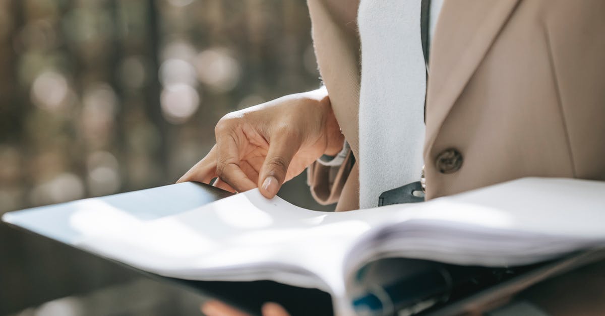 Photocopies of important documents stolen - Crop faceless female entrepreneur in stylish jacket reading important documents in black folder Photocopies of important documents stolen - Crop faceless female entrepreneur in stylish jacket reading important documents in black folder