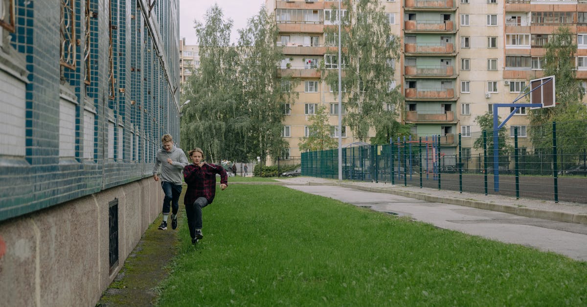 Photography and Running in the Christiania Neighbourhood of Copenhagen - Young Men Running on the Green Grass Near the Buildings Photography and Running in the Christiania Neighbourhood of Copenhagen - Young Men Running on the Green Grass Near the Buildings