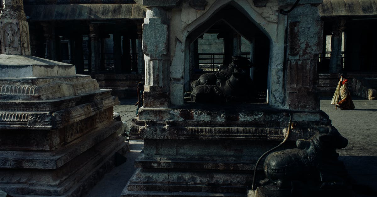 Place for long stay in North India - Weathered oriental stone sculptures statues and buildings located in medieval historic Hampi village in India