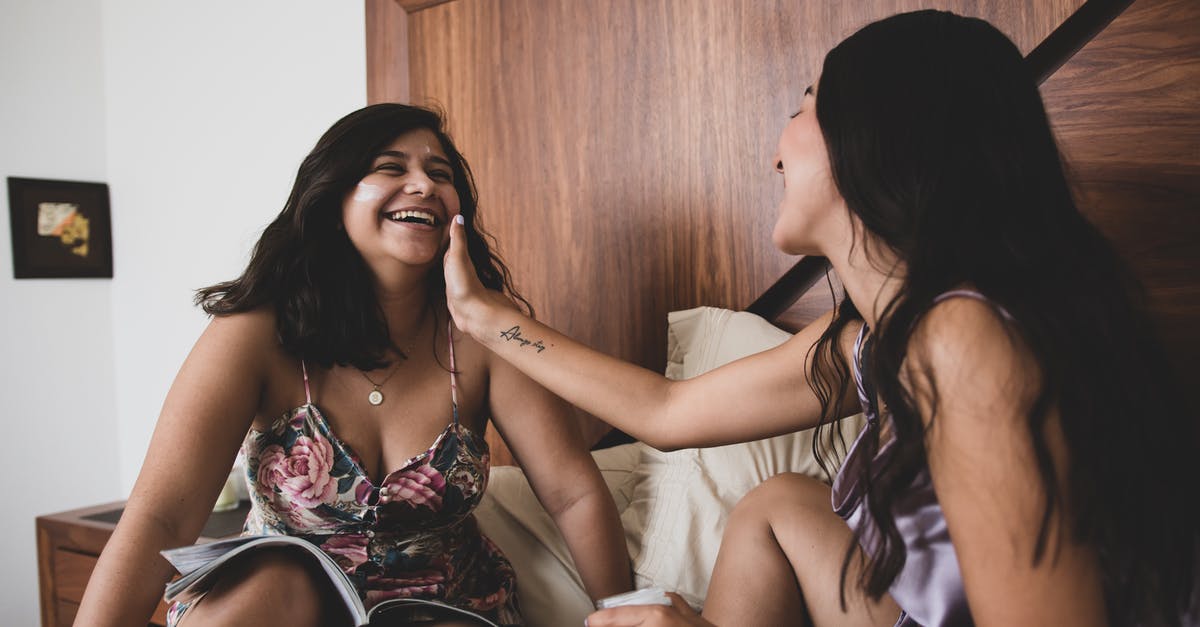 Place of stay on my approved ESTA is different to where I'm actually staying due to bad communication. Should I re-apply? [duplicate] - A Woman Putting a Cream on Her Friend's Face while Sitting on the Bed
