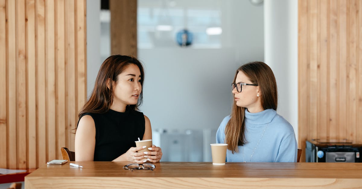 Planning girlfriend visiting me in the UK - Diverse women talking during coffee break at table Planning girlfriend visiting me in the UK - Diverse women talking during coffee break at table
