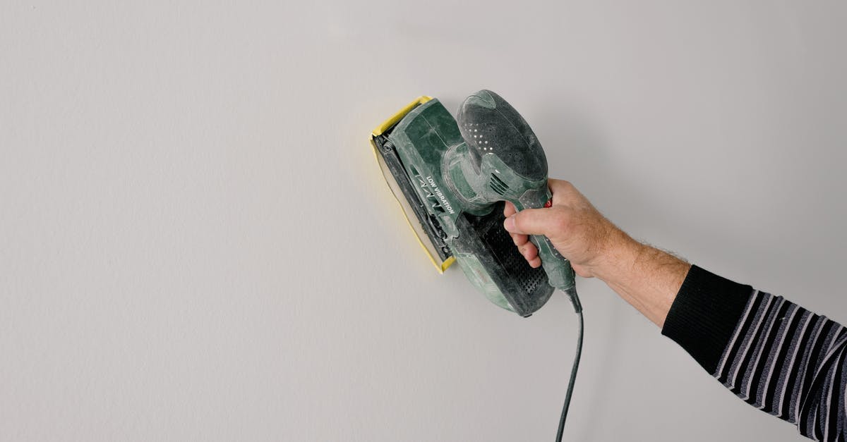Polish Airports' fingerprint Process - Repairman polishing wall with construction tool Polish Airports' fingerprint Process - Repairman polishing wall with construction tool