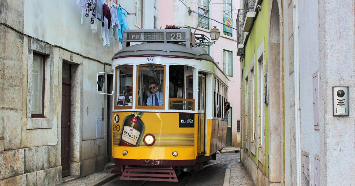 Portuguese cuisine in Lisbon - Famous old fashioned number 28 Lisbon tram in narrow street of Lisbon with shabby buildings Portuguese cuisine in Lisbon - Famous old fashioned number 28 Lisbon tram in narrow street of Lisbon with shabby buildings