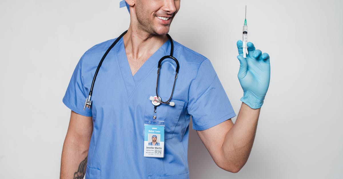 Positive drug test in Singapore: How long do I need to avoid the country? - Smiling male doctor in uniform and gloves with stethoscope holding syringe while standing against white background in clinic Positive drug test in Singapore: How long do I need to avoid the country? - Smiling male doctor in uniform and gloves with stethoscope holding syringe while standing against white background in clinic