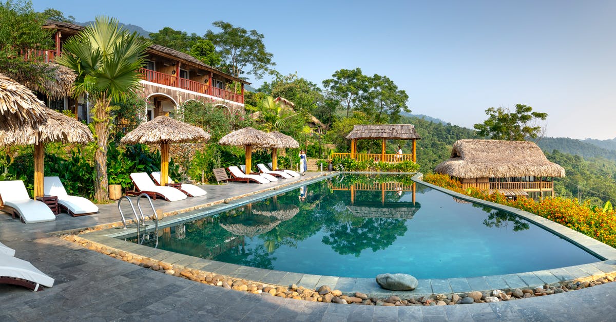 Possible to Travel to A Quiet Place? - Exotic resort hotel with swimming pool with deckchairs and umbrellas located in calm tropical place Possible to Travel to A Quiet Place? - Exotic resort hotel with swimming pool with deckchairs and umbrellas located in calm tropical place