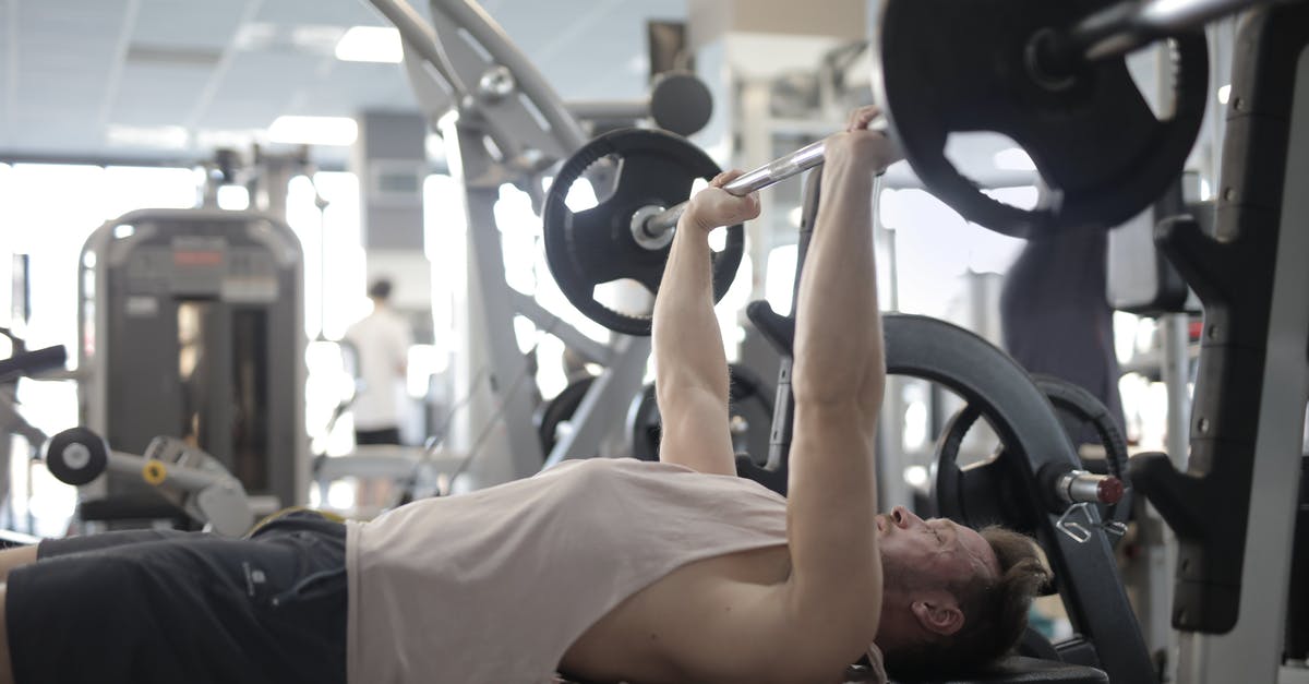 Power plugs in train repeatedly turning off - Muscular sportsman training with heavy barbell during weightlifting workout in modern gym Power plugs in train repeatedly turning off - Muscular sportsman training with heavy barbell during weightlifting workout in modern gym