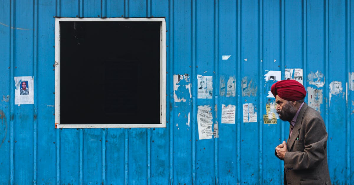 Practical aspects of security when travelling in India - Man in Black Jacket Standing Beside Blue Wooden Door Practical aspects of security when travelling in India - Man in Black Jacket Standing Beside Blue Wooden Door