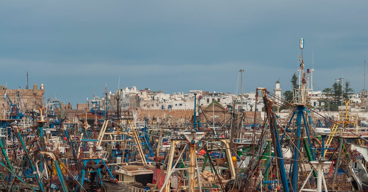 Precautions and Customs to observe when traveling in Morocco - Old boats moored on embankment of seaport Precautions and Customs to observe when traveling in Morocco - Old boats moored on embankment of seaport