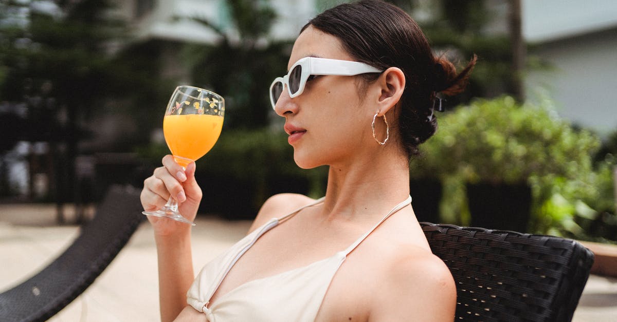 Price limits for self-arranged hotel after flight cancellation - Stylish young ethnic woman drinking smoothie while chilling on sunbed in resort Price limits for self-arranged hotel after flight cancellation - Stylish young ethnic woman drinking smoothie while chilling on sunbed in resort