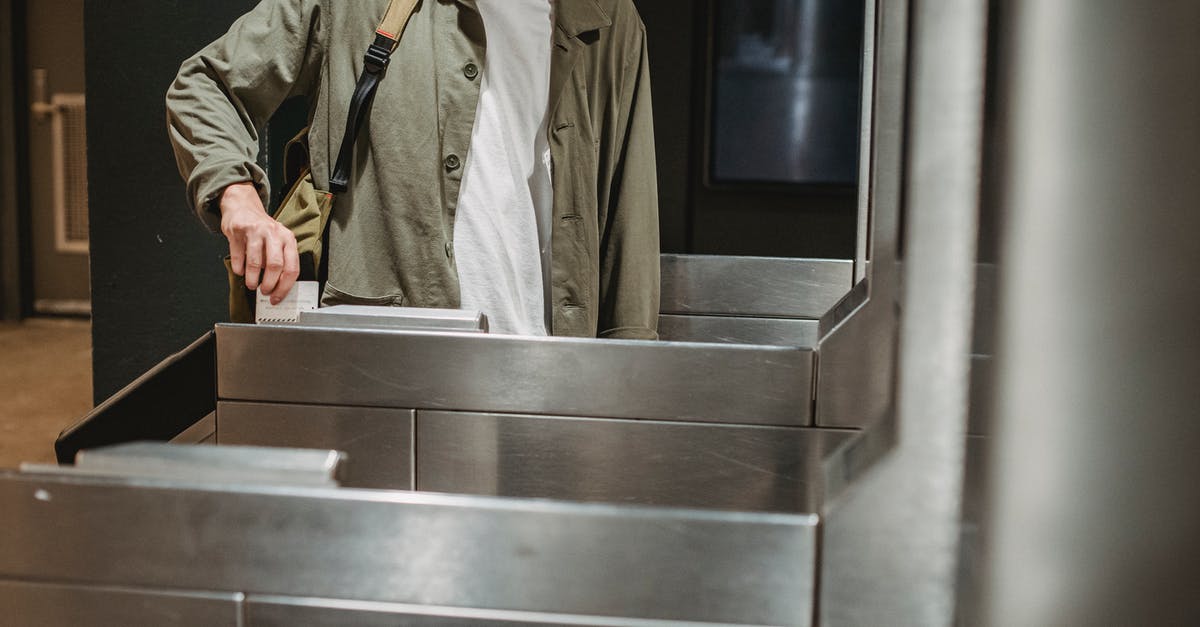 Price of train tickets in Geneva - Crop unrecognizable male passenger in casual clothes with backpack inserting ticket in entrance machine of automated gate while entering modern subway station Price of train tickets in Geneva - Crop unrecognizable male passenger in casual clothes with backpack inserting ticket in entrance machine of automated gate while entering modern subway station