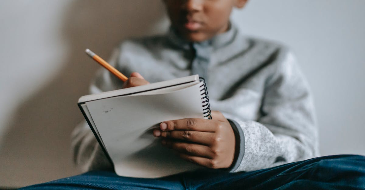Primary occupation for the US visa - student or professional? - Low angle of crop smart ethnic boy sitting on floor with notepad and writing Primary occupation for the US visa - student or professional? - Low angle of crop smart ethnic boy sitting on floor with notepad and writing