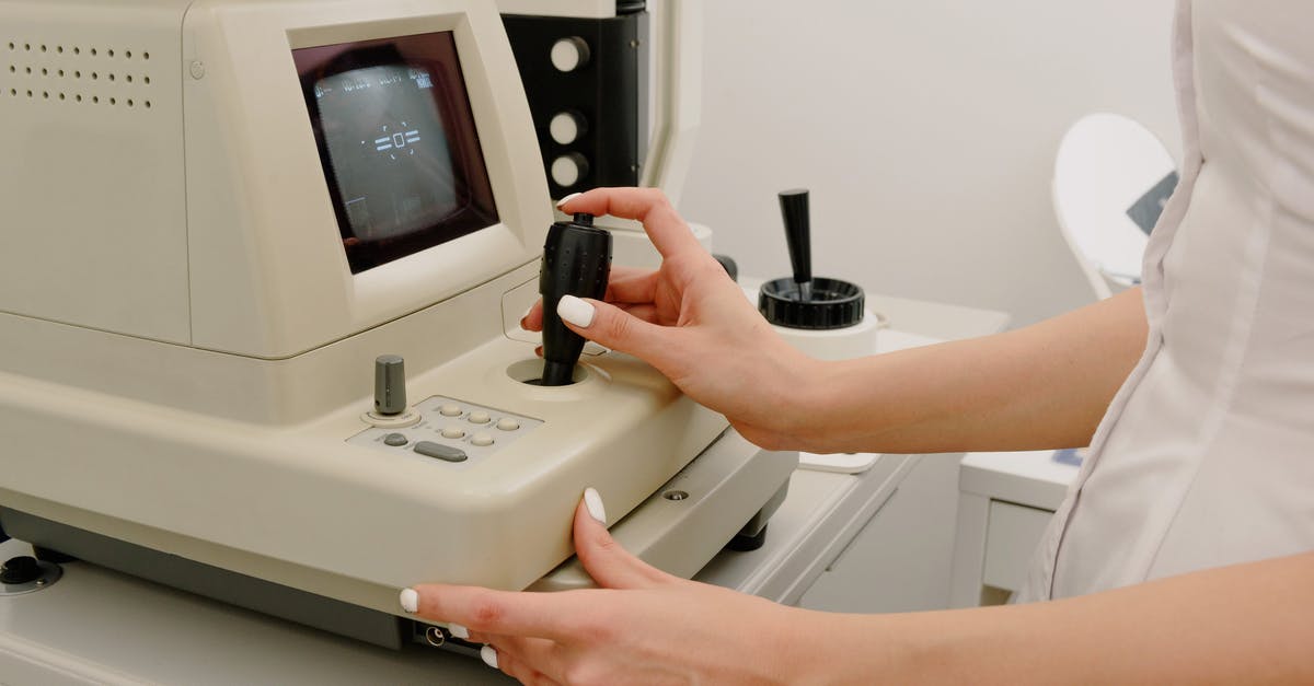 Processing Time for a Canadian Study permit with a late request for a Medical Exam [closed] - Side view of crop faceless female ophthalmologist using autorefraktometer for corneal topography in contemporary medical office